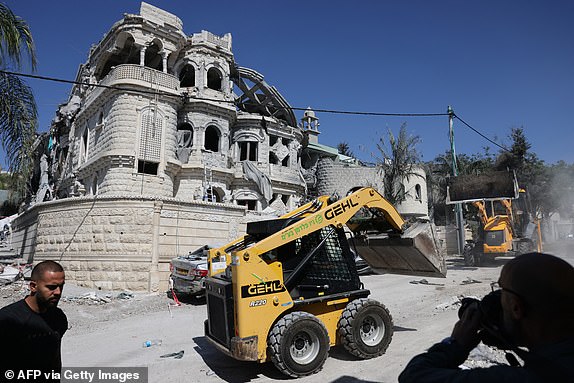 Municipal workers clear the wreckage and debris in the northern Israeli town of Tamra, following an overnigh missile attack from Iran on June 15, 2025, where four people were reported killed. Israel unleashed a punishing barrage of strikes targeting the capital Tehran on June 15, after Prime Minister Benjamin Netanyahu vowed to make Iran pay "a very heavy price" for killing civilians, on the third day of fierce fighting. (Photo by AHMAD GHARABLI / AFP) (Photo by AHMAD GHARABLI/AFP via Getty Images)