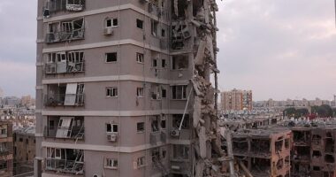 People stand near a residential building that was hit following missile attack from Iran on Israel, at central Israel June 15, 2025
