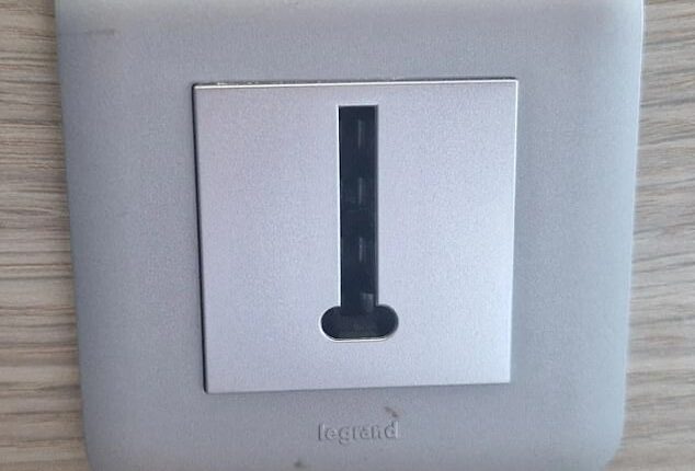 The British hotel guest posted a photo of a wall plate featuring a small rectangular opening marked with the word 'Legrand' and asked: 'What is this thing?'