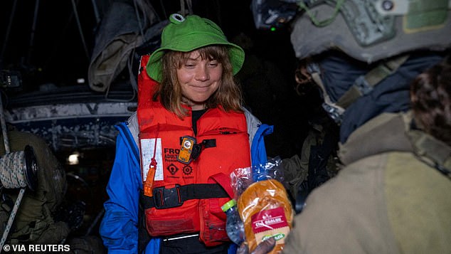 The climate campaigner-turned-Palestine freedom fighter, safe in an orange life jacket and a green frog-shaped sun hat, gazing at the Israeli sandwich with a hungry smile