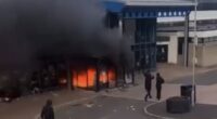 Distressing footage taken outside Larne Leisure Centre tonight shows a group of hooded thugs torching the building, which is understood to have held Romanian immigrants