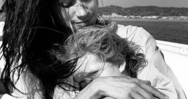 The Duchess of Sussex shared the black and white photo of herself cuddling Princess Lilibet, who was sat on her lap, with the pair both sporting windswept hair, seemingly on a boat