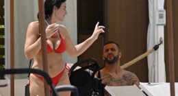 Annie Kilner, 32, showing off her stunning figure in a red bikini as she sipped an iced drink next to Kyle Walker, 34, at the Orlando theme park resort