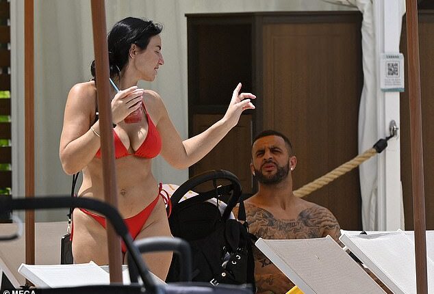 Annie Kilner, 32, showing off her stunning figure in a red bikini as she sipped an iced drink next to Kyle Walker, 34, at the Orlando theme park resort
