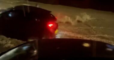 Dramatic footage taken in Dover last night shows an intense stream of water flowing down a residential road, before a moving car with its hazard lights on comes into view