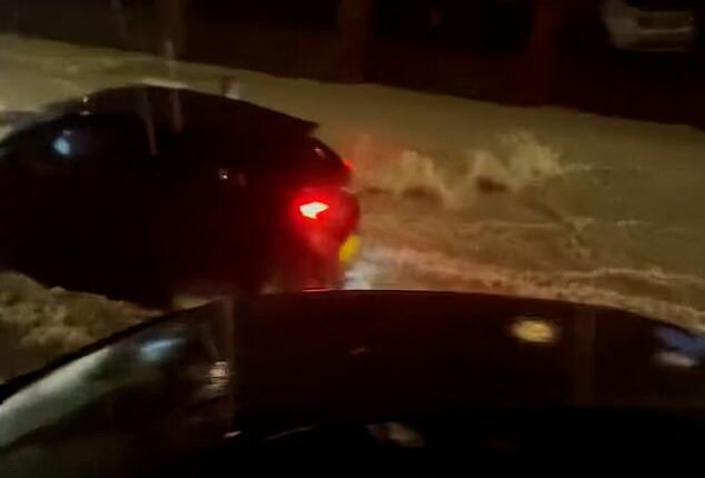Dramatic footage taken in Dover last night shows an intense stream of water flowing down a residential road, before a moving car with its hazard lights on comes into view