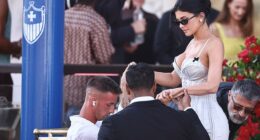 Fashion faux-pas! Kylie Jenner wore a tight, curve-hugging corset dress that looked way too close to white. It appeared to have frayed detailing on the chest and back, as well as two black bows on the straps. She completed the look with a pair of small black sunglasses and large stud earrings