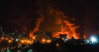 Fire and smoke rise into the sky after an Israeli attack on an oil depot in Tehran, Iran, at dawn on Sunday, June 15, 2025