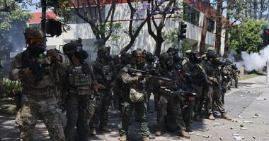Federal agents hold a line during a clash with protesters near a Home Depot after a raid was conducted by Immigration and Customs Enforcement (ICE) in Paramount, California on Saturday