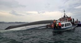 Relief personnel gathered around a capsized tourist boat, which had been carrying 53 passengers when it capsized - of these at least 34 are believed to have died