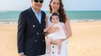 Wall Street billionaire John Paulson is all smiles in sun-soaked family portrait posted to Instagram on Friday as he is seen wrapping his arm around his glamorous, much-younger fiancée who is holding their baby daughter