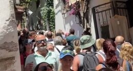 Europe is groaning under a tourism surge. Shocking footage reveal the extent of the crisis, with some streets so crowded that tourists are forced to shuffle shoulder-to-shoulder just to move. Pictured:  A street in Positano, Italy