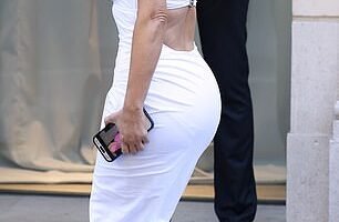 Kim Kardashian was caught googling herself as she brought back the booty in a second block colour latex dress and quirky boots from controversial designer Balenciaga as she arrived for their show in Paris on Wednesday