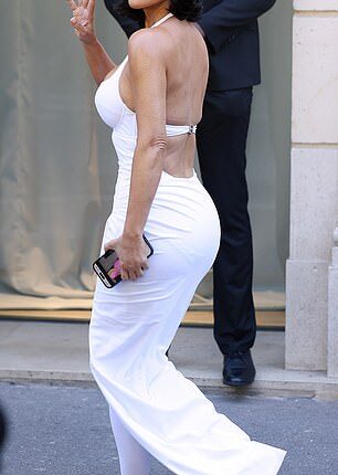 Kim Kardashian was caught googling herself as she brought back the booty in a second block colour latex dress and quirky boots from controversial designer Balenciaga as she arrived for their show in Paris on Wednesday