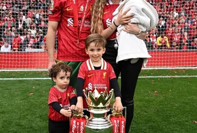 The couple have three children, pictured on the Anfield pitch in May after winning the Premier League