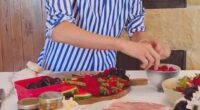 In the clip, Meghan introduced her board as 'easy entertaining,' and decorated a wooden board with various fruits, cheeses, and crackers, as well as her sold-out, $14 As Ever raspberry spread