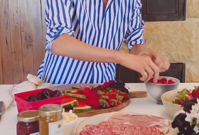 In the clip, Meghan introduced her board as 'easy entertaining,' and decorated a wooden board with various fruits, cheeses, and crackers, as well as her sold-out, $14 As Ever raspberry spread