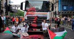 "Youth Demand" activists holding Palestinian flags glue themselves to a truck during the 2025 Pride Parade in London