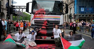 "Youth Demand" activists holding Palestinian flags glue themselves to a truck during the 2025 Pride Parade in London