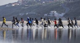 Migrants waiting to cross the Channel yesterday laughed at the notion the Government’s new deal with France would stop the boats. Pictured: Migrants rush to try to board a smuggler's boat in an attempt to cross the English Channel in June this year