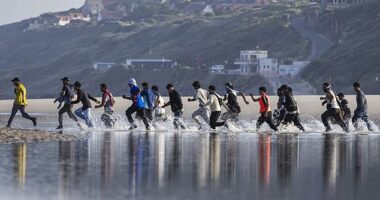 Migrants waiting to cross the Channel yesterday laughed at the notion the Government’s new deal with France would stop the boats. Pictured: Migrants rush to try to board a smuggler's boat in an attempt to cross the English Channel in June this year
