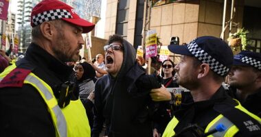 A protester who was asked to remove his face mask shouts at a police officer whilst taking part in the Stand Up to Racism rally outside the Britannia International Hotel in Canary Wharf