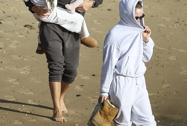 Justin Hemmes looked every inch the doting dad as he cradled his two young children before boarding a seaplane in Sydney with partner Madeline Holtznagel on Friday