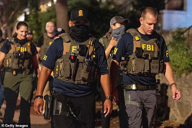 FBI agents walk down Florida Ave between 14th street NW and 13th street NW on August 13, 2025 in Washington, DC