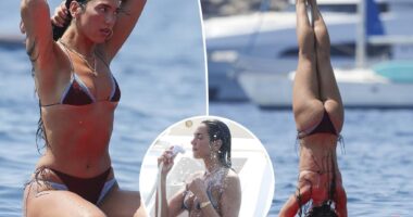 Dua Lipa flaunts her abs during paddleboard yoga in Ibiza