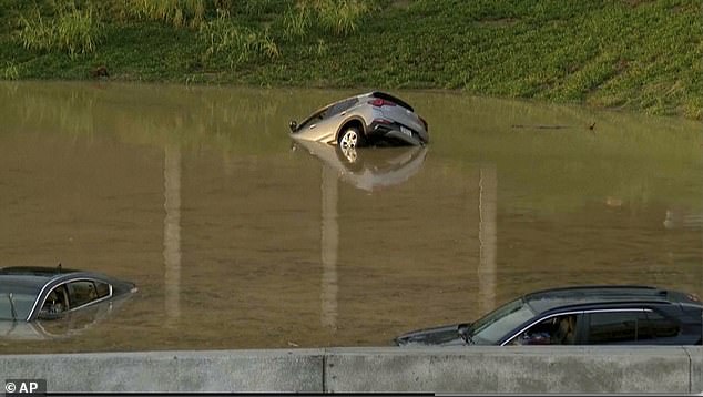 Three people, including a child, were crushed to death by a falling tree as disastrous floods hit Tennessee overnight. (Pictured: File Photo of sinking car in flood water in Chattanooga)