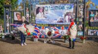 Royal fans were sombre as they gathered outside Kensington Palace to mark Princess Diana 's death anniversary after a fatal car crash in Paris claimed her life 28 years ago