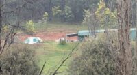 Heavily-armed police have guns drawn as they swarm on property in hunt for alleged cop killer: Live updates