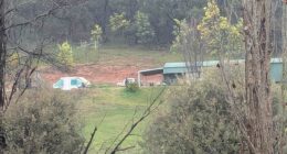 Heavily-armed police have guns drawn as they swarm on property in hunt for alleged cop killer: Live updates