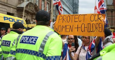 Police officers stand guard as anti-immigration protesters gather in Liverpool, Britain, August 9, 2025