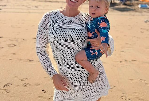 In the first photo she posted, Karoline Leavitt smiled on the beach as she held her one-year-old, who was wearing an adorable bathing suit with crabs all over it