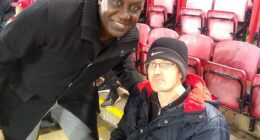 This is Mark Mogan, the disabled Liverpool fan, pictured right with Emile Heskey, who was arrested for allegedly shouting racist abuse at Bournemouth player Antoine Semenyo