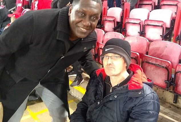 This is Mark Mogan, the disabled Liverpool fan, pictured right with Emile Heskey, who was arrested for allegedly shouting racist abuse at Bournemouth player Antoine Semenyo
