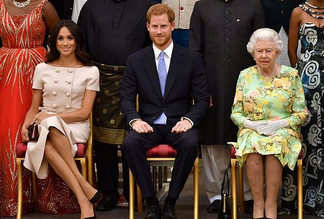 Meghan is pictured with Prince Harry and the late Queen Elizabeth II