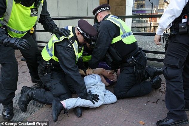 Swarms of anti-migrant demonstrators have taken to asylum seeker hotels across the country as protestors clash with police ahead of more chaos this weekend. Pictured: Officers have made two arrests in Canary Wharf