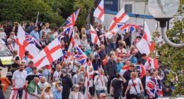 Crowds of anti-migrant demonstrators holding English flags and Union Jacks gather outside the Crowne Plaza hotel in West Drayton