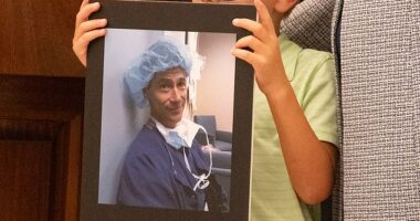 Family members who lost loved ones to distracted driving held up signs in their honor during the July 31 ceremony (pictured: a little boy holding a picture of Dale Willenberg, who died in 2017 when he was hit by a distracted driver)