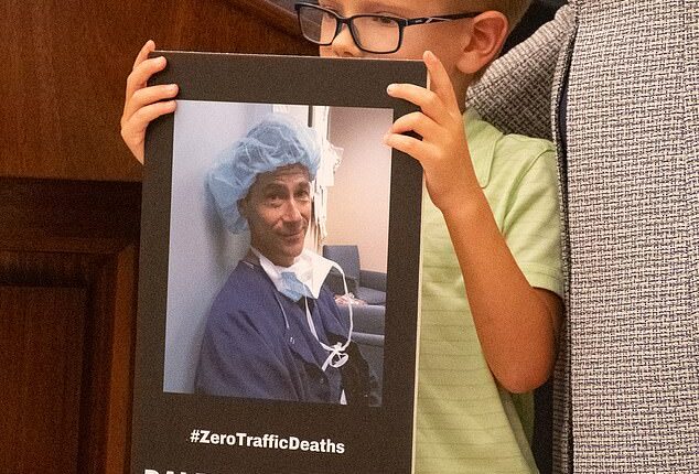 Family members who lost loved ones to distracted driving held up signs in their honor during the July 31 ceremony (pictured: a little boy holding a picture of Dale Willenberg, who died in 2017 when he was hit by a distracted driver)