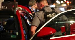 Troops with the National Guard arrived into the capital late on Tuesday night in a bid by the White House to curb violent crime, a US Marshal can be seen searching a vehicle on Tuesday