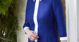 The photograph released to mark the Princess Royal's 75th birthday - Princess Anne wears a blue and white dress while leaning by a windowsill at her private residence, Gatcombe Park