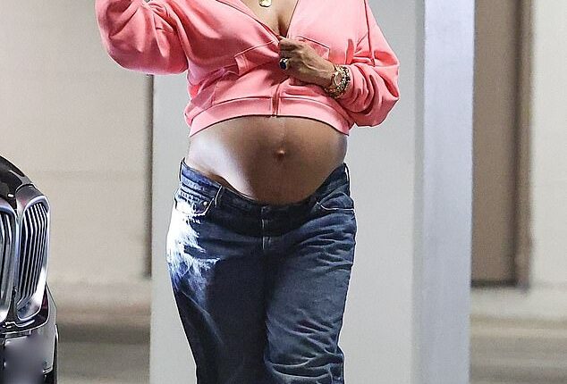 Rihanna proved she has maternity style nailed as she stepped out in low-slung jeans with a pink hoodie and her blossoming bump on full display on Monday