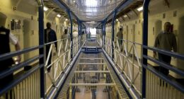 File image of prison officers and prisoners walking down the corridor of the A wing at HMP Wandsworth