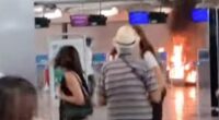 Stunned holidaymakers look on towards a fire lit in Terminal 1 of Milan Malpensa airport