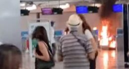 Stunned holidaymakers look on towards a fire lit in Terminal 1 of Milan Malpensa airport