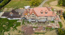 TODAY: The entire facade of the faux-Tudor house is clad in scaffolding with construction materials, including planks of wood, scattered in the driveway