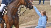 Mia Tindall is pictured petting her mother Zara's horse Showtime, while attending the Horse Trials at Hartpury in Gloucestershire on Saturday